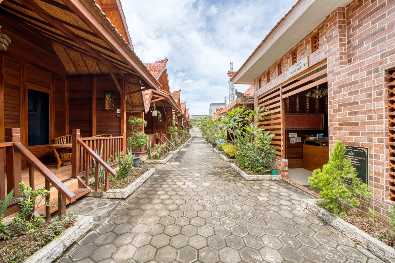 Garden walkway between wooden villas and the brick front office